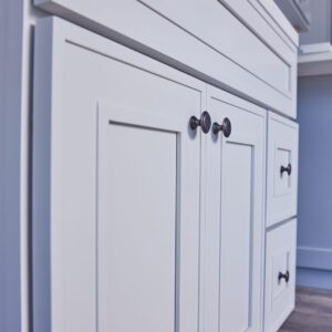 White kitchen cabinet with modern handles.