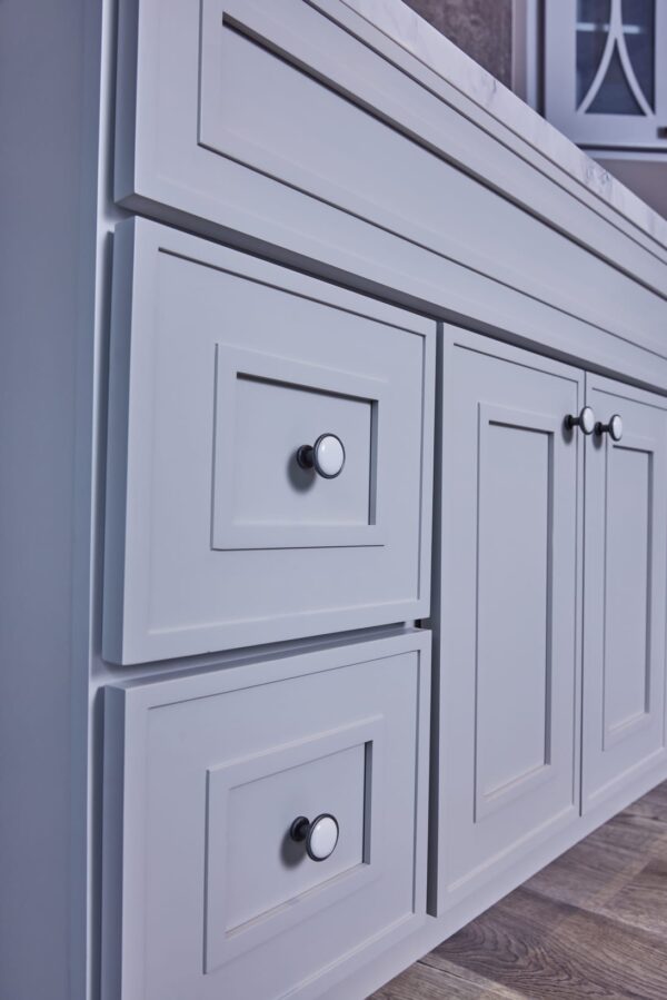 White kitchen cabinet with silver knobs.